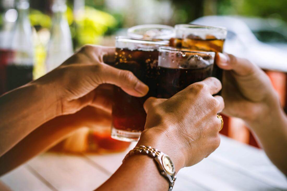 Coca-Cola vs Pepsi: маркетинговые войны и стратегии брендов — фото напитков в стаканах у людей в ресторане — American Butler