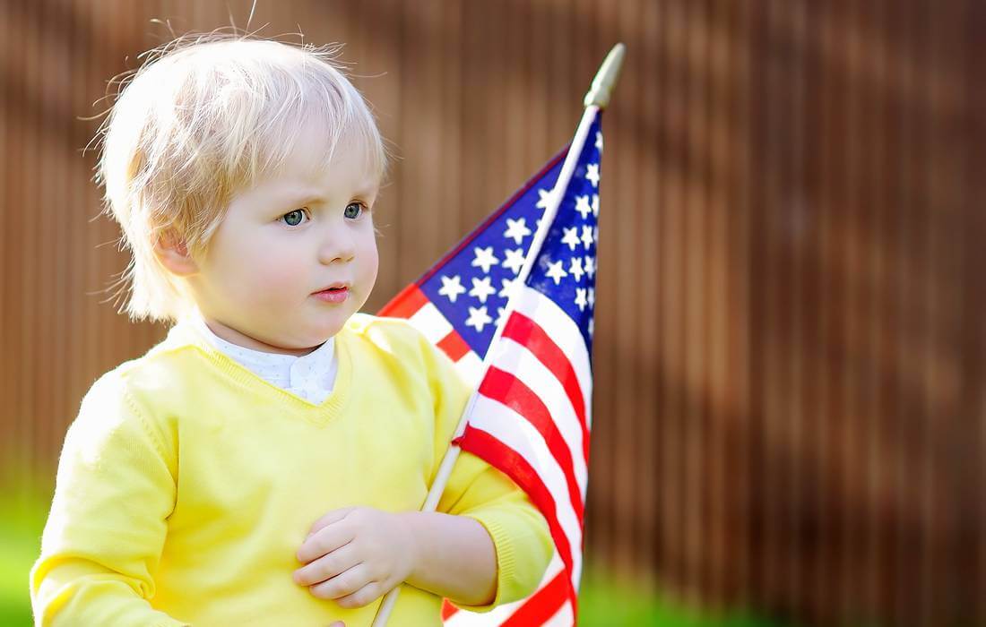 American dream values — photo of a child with a flag on the background of the house — American Butler