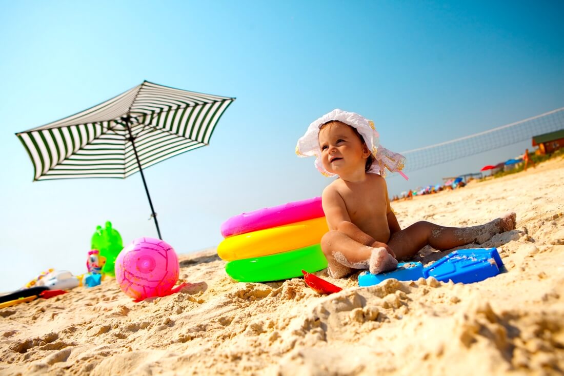 Расходы на детей в США — фото девочки с игрушками на пляже — American Butler