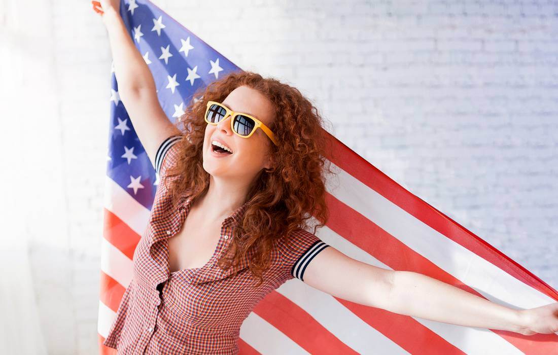 Особенности и отличия жизни в США от России — фото девушки с американским флагом — American Butler
