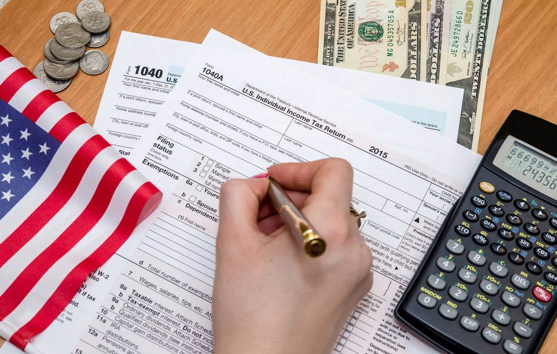 How to pay taxes in the USA — photo of a tax return and a calculator — American Butler
