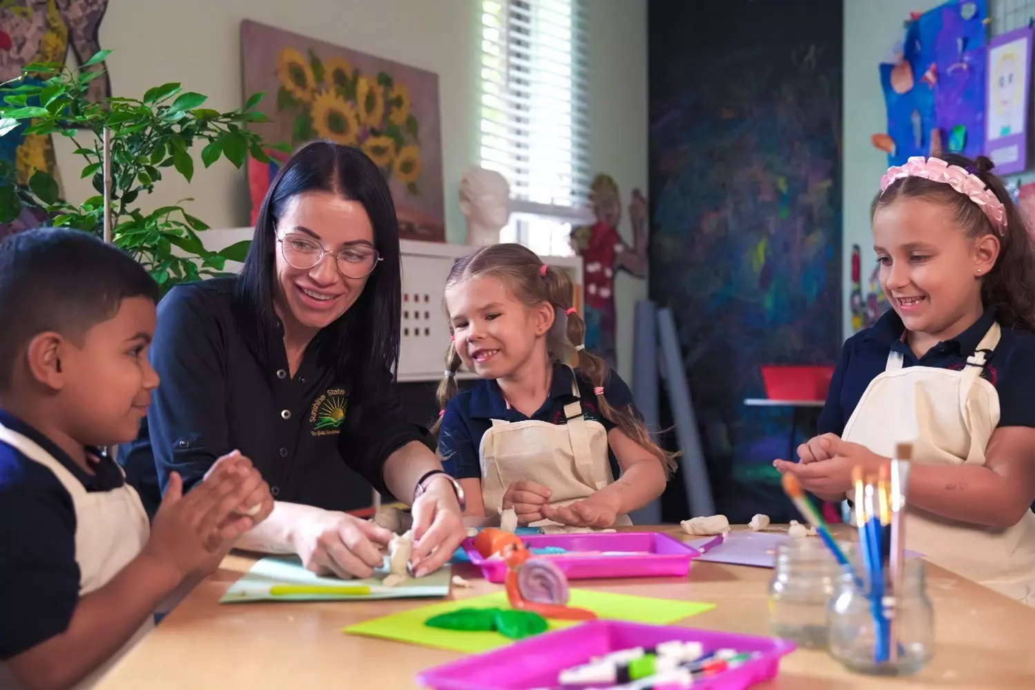 Exploring Art at Sunshine State Academy Preschool in Miami Young students at Sunshine State Academy in Miami happily engage in a hands-on art activity, using paint and vibrant colors to express their creativity