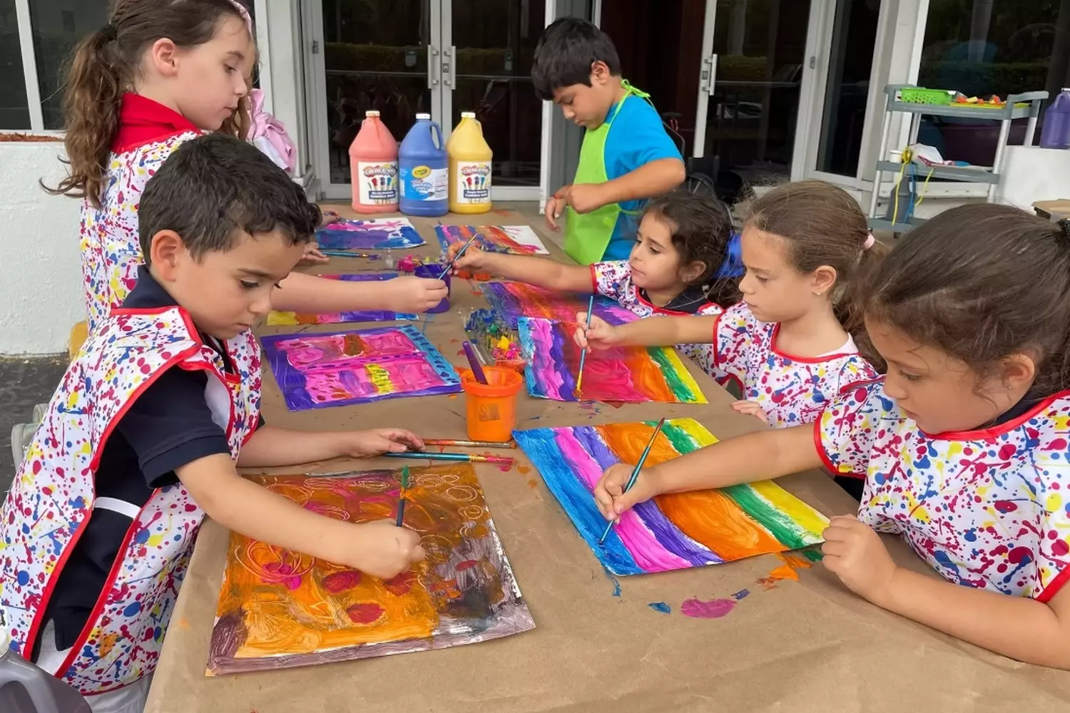 Creative Art Class at Tauber Academy Preschool in Aventura Young children at Tauber Academy in Aventura happily painting with bright colors during an art lesson, developing creativity