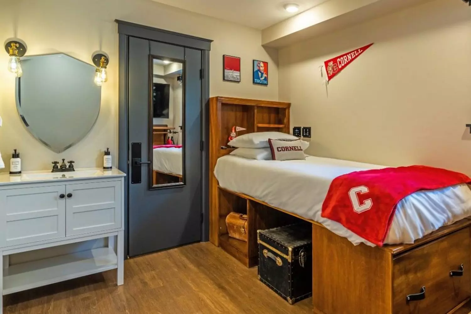 Тёплая и обустроенная комната в общежитии Корнеллского университета с аккуратной кроватью, рабочим столом и личными фотографиями на стенах