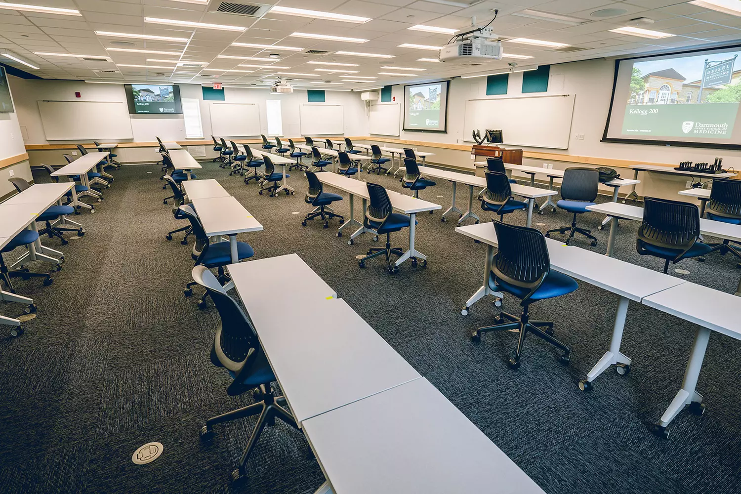 Будущее обучения: внутри современной аудитории Дартмута Светлая современная аудитория в Дартмутском колледже с амфитеатром, большими цифровыми экранами и студентами, занятыми совместной работой