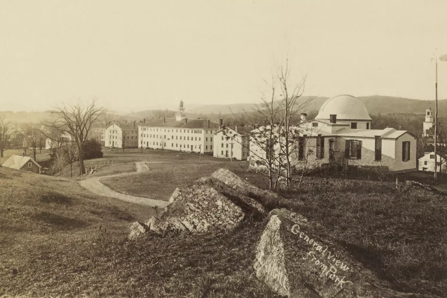 Взгляд в прошлое: Дартмутский колледж на винтажной фотографии Чёрно-белое или сепия историческое фото Дартмутского колледжа: здания из красного кирпича, старинные дорожки и студенты в одежде прошлой эпохи