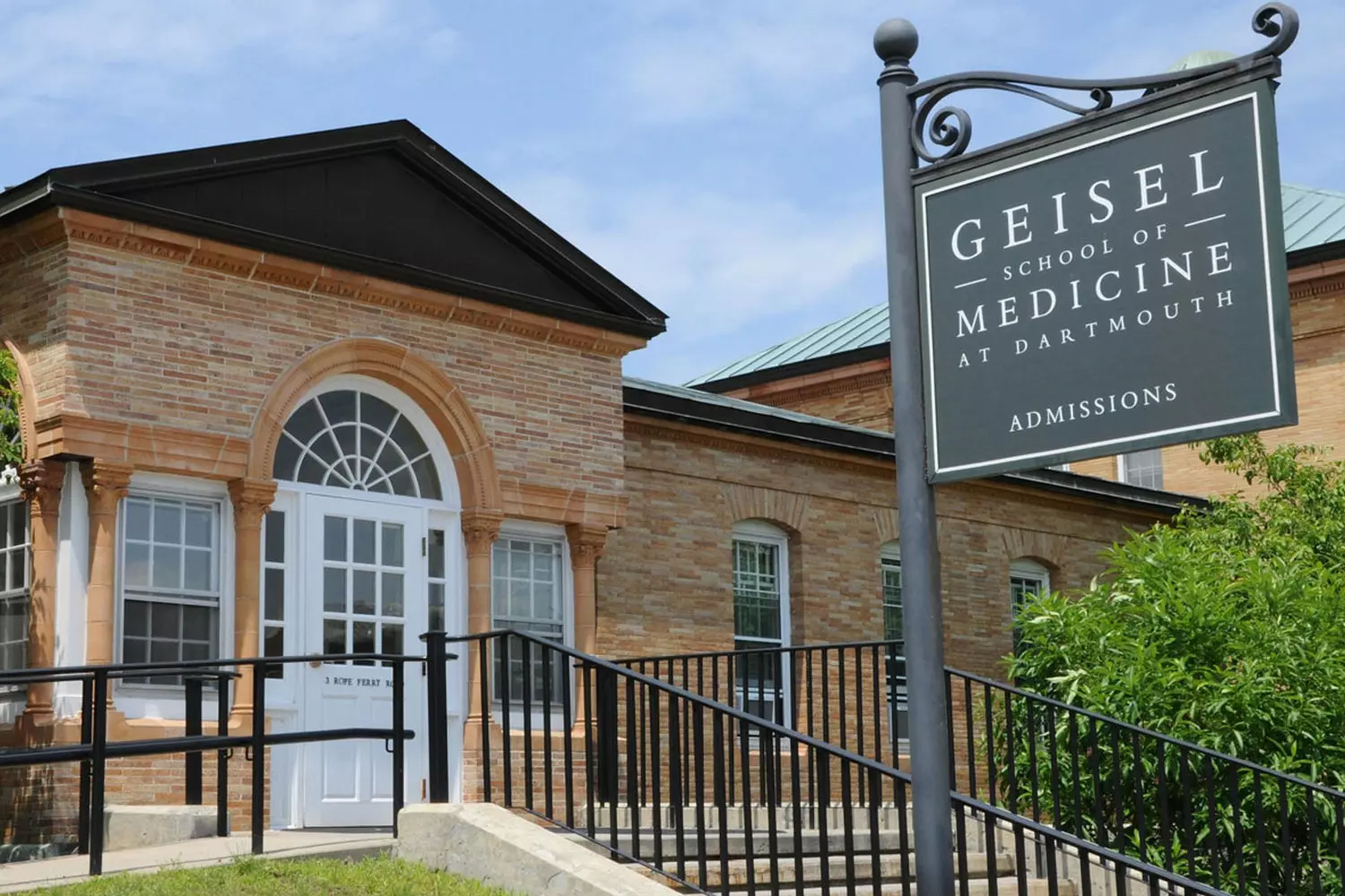 Будущее медицины: обучение и инновации в Медицинской школе Гейзела Дартмута Здание Медицинской школы Гейзела Дартмута, студенты-медики беседуют у входа в здание из стекла и бетона