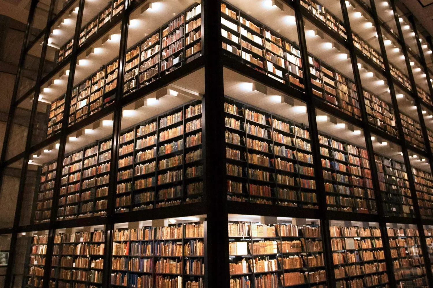 The Past in the Present: Rare Books in the Glass Heart of the Beinecke Library Inside the Beinecke Library: a modern glass atrium with multi-tiered shelves of rare books and manuscripts