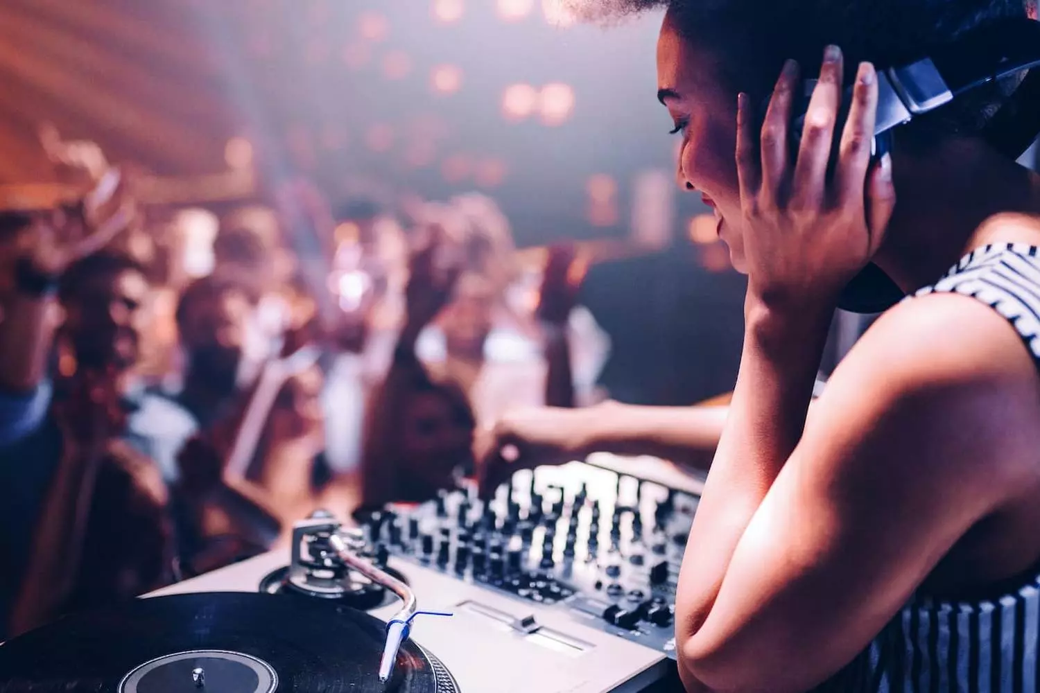 DJ Spinning Tracks Under Miami Neon Lights | Nightlife Vibes DJ performing at a vibrant nightclub in Miami with neon lights and a dancing crowd