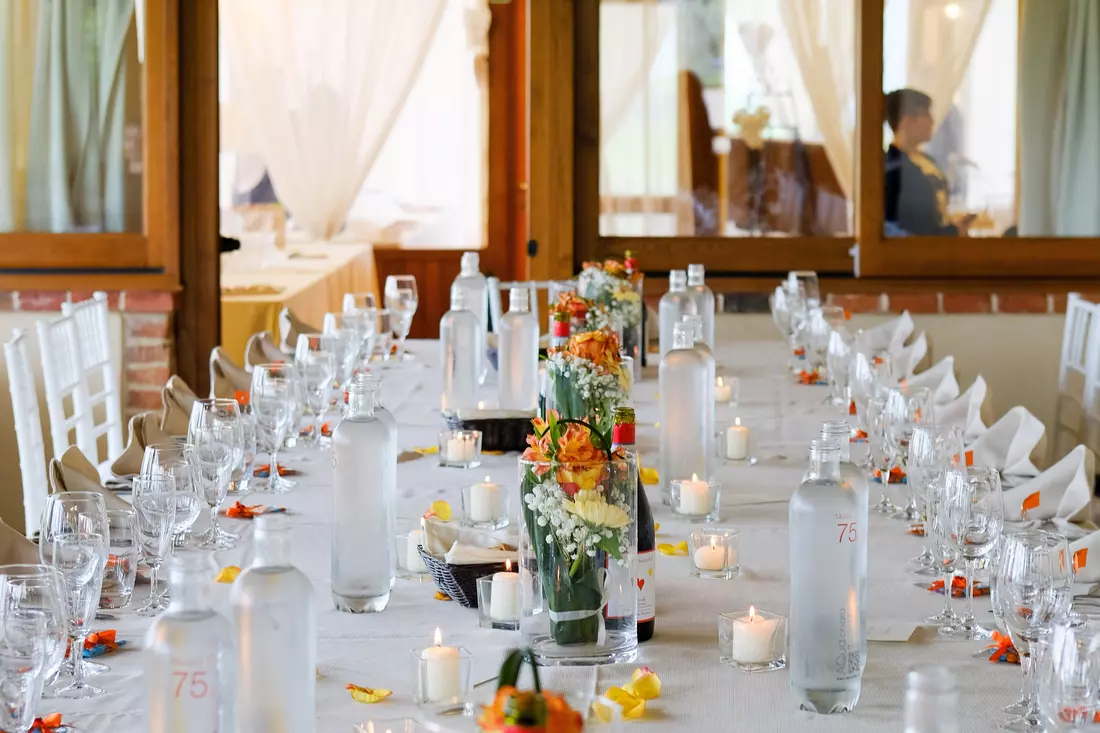 The photo shows a wedding table in a restaurant in Miami. The table is decorated in a luxurious style with beautiful flowers and candles. In the background you can see the interior of the restaurant with beautiful lighting