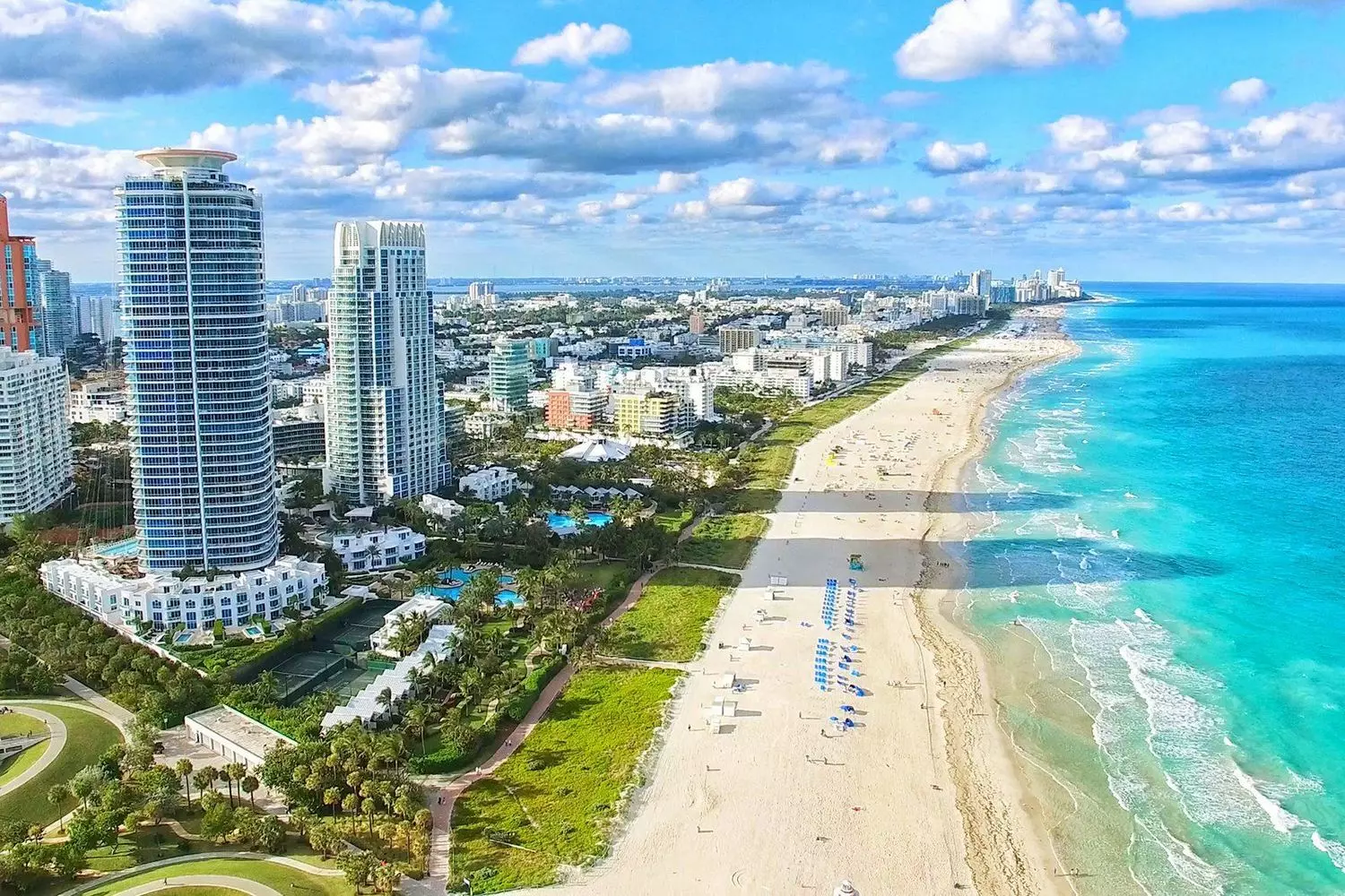 Bird's-eye panorama of Miami showcasing modern Downtown skyscrapers against the ocean coastline and sandy beaches