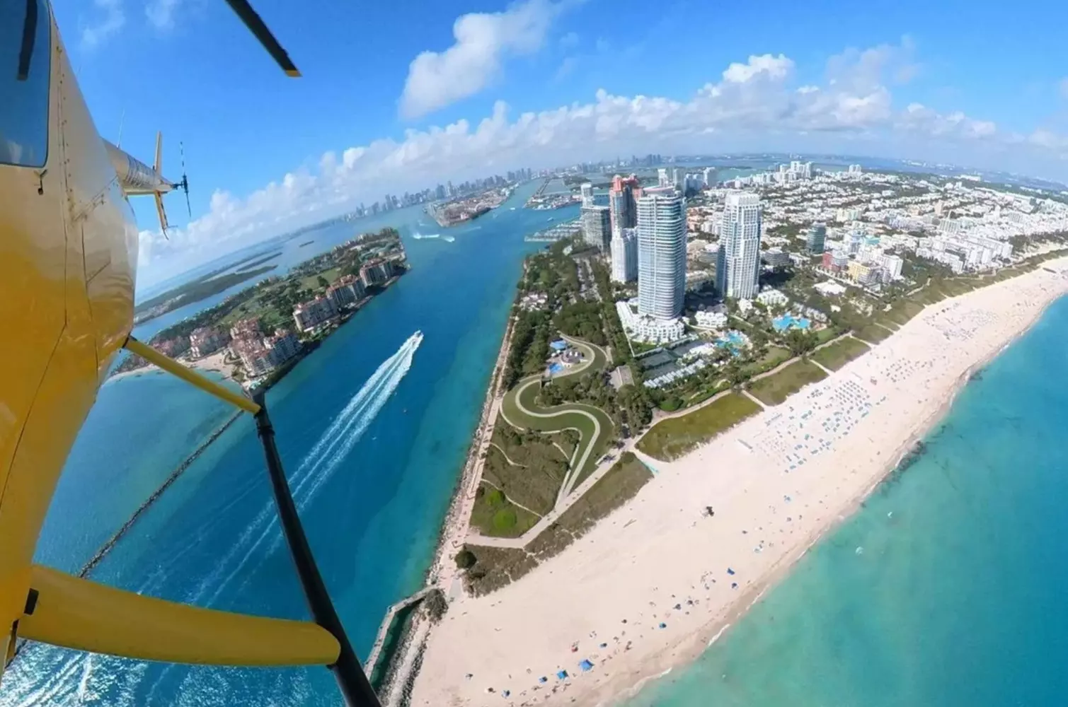 Helicopter Soaring Over Florida — Aerial View of the Coastline A helicopter flying over the sunny skies of Florida with the ocean and cityscape in the background