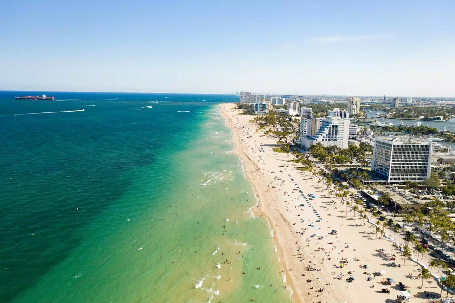 Fort Lauderdale Coastline from Above | Helicopter Aerial View of Atlantic Ocean Panoramic aerial view of Fort Lauderdale's coastline from a helicopter, featuring sandy beaches, Atlantic Ocean waves, beachfront hotels, and yachts along the shore