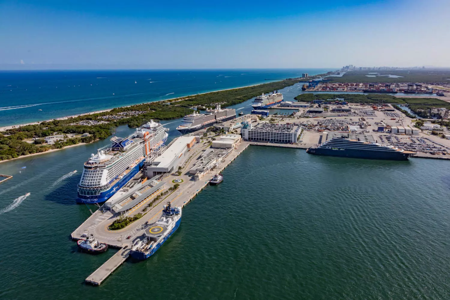 Fort Lauderdale Cruise Port from Above | Port Everglades Helicopter Aerial View Panoramic aerial view of Fort Lauderdale's cruise port (Port Everglades) from a helicopter, featuring massive cruise ships at dock, container terminals, and the passage to the Atlantic Ocean