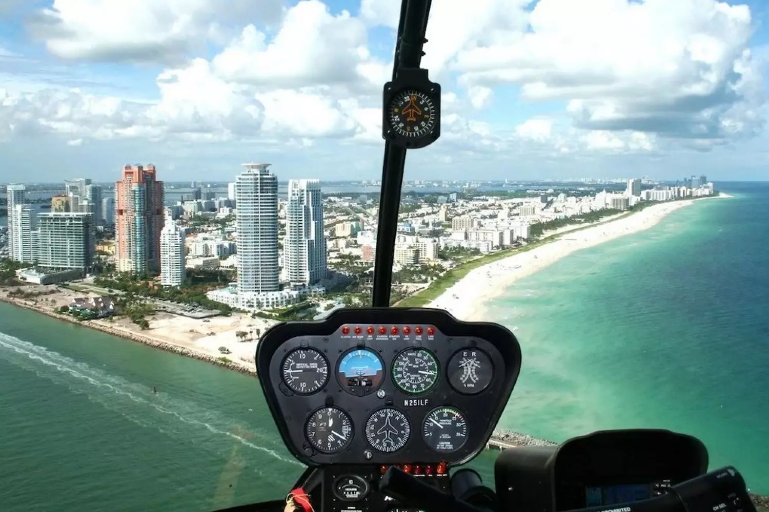 Helicopter Soaring Over Miami — Aerial View of the Coastline A helicopter flying over the sunny skies of Miami with the ocean and cityscape in the background