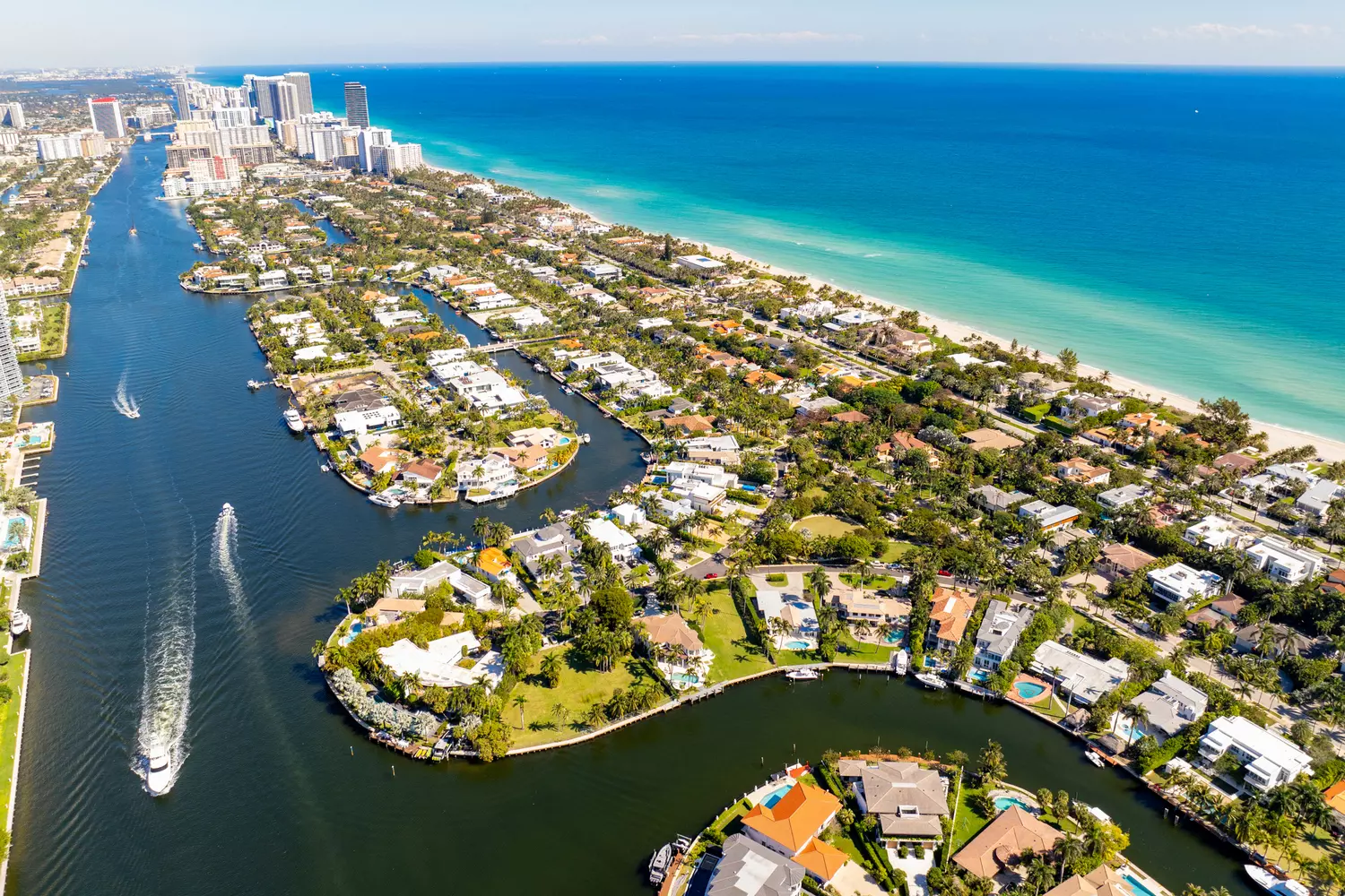 Helicopter aerial view of the Florida coastline featuring luxury villas and turquoise ocean waters from a bird's eye perspective
