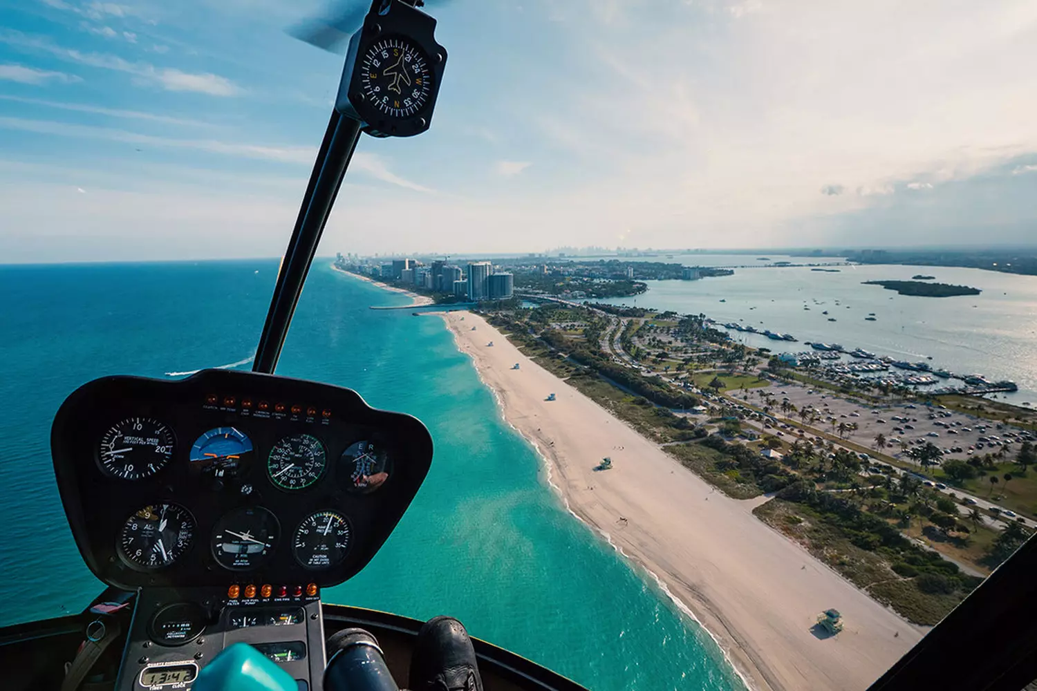 Helicopter Soaring Over North Miami Beach — Aerial View of the Coastline A helicopter flying over the sunny skies of North Miami Beach with the ocean and cityscape in the background