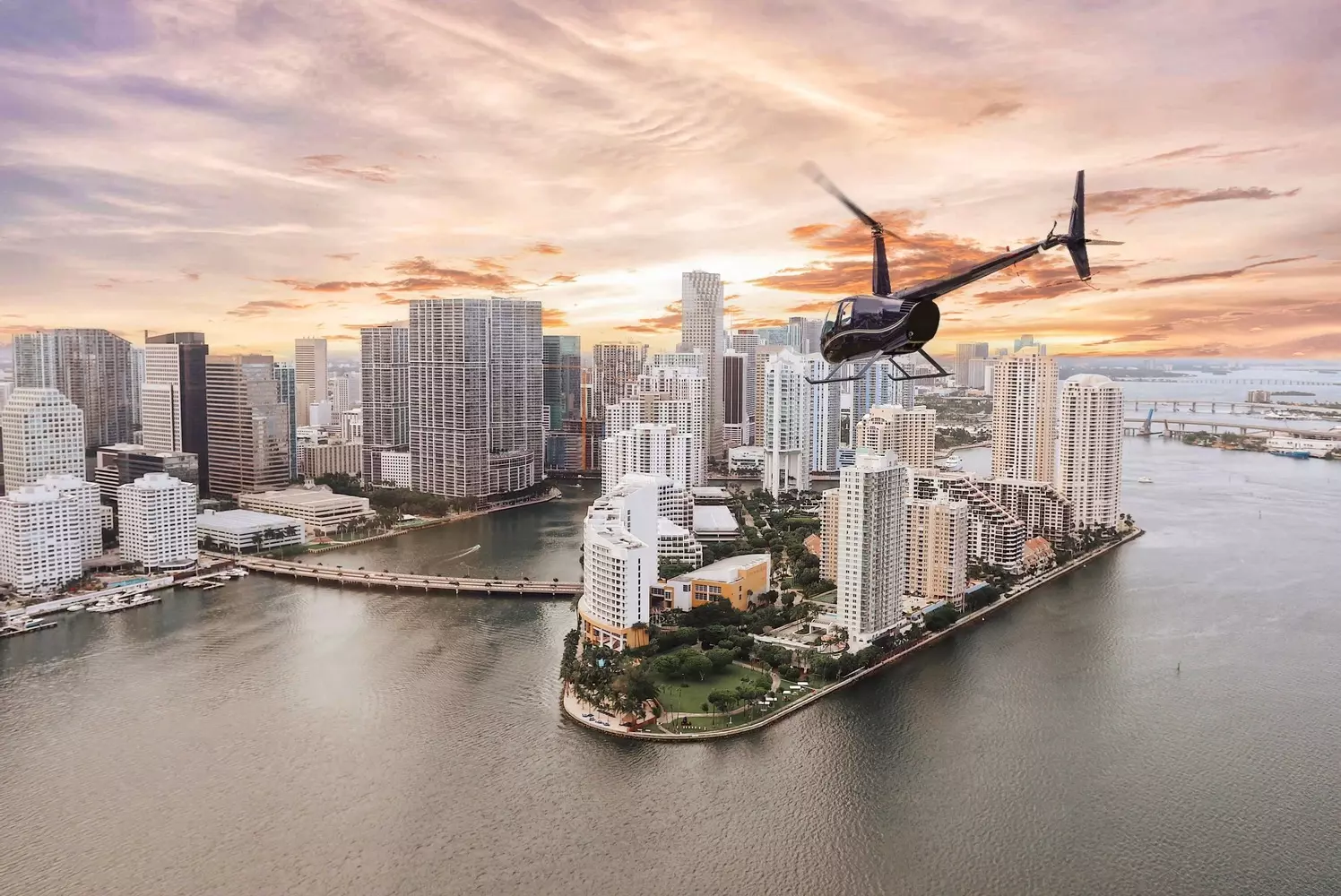 Helicopter Soaring Over North Miami Beach — Aerial View of the Coastline A helicopter flying over the sunny skies of North Miami Beach with the ocean and cityscape in the background