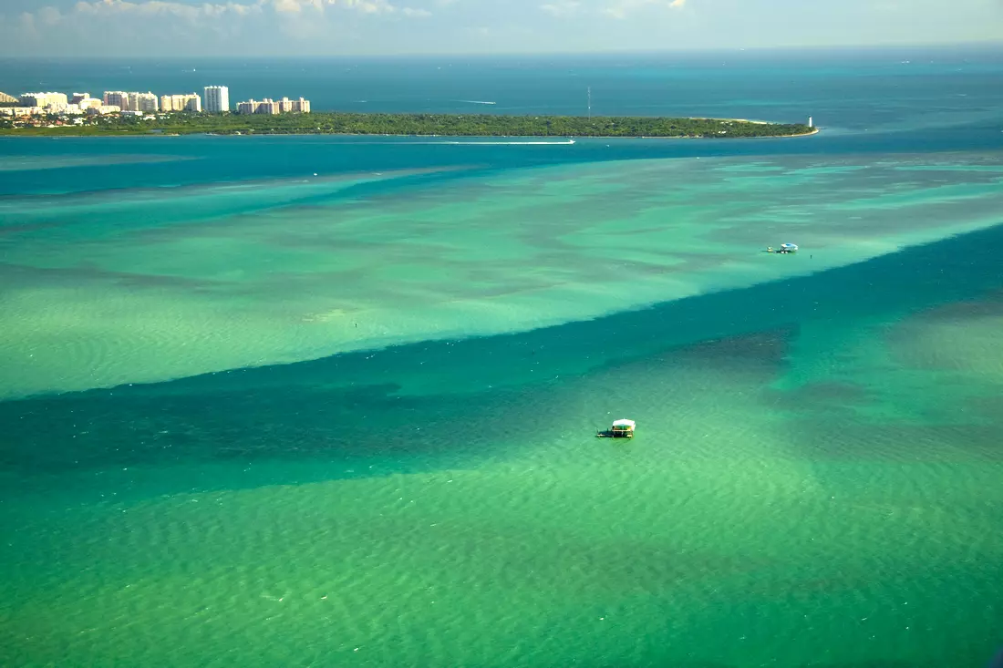 A view of the waters of Biscayne Bay and the historic settlement of Stiltsville in the distance, with homes on stilts surrounded by turquoise waters