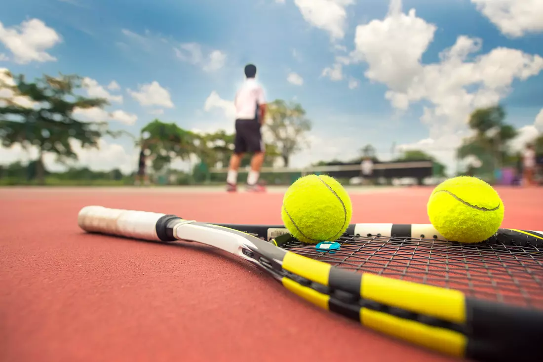 Photo of a tennis racket and balls on a court in Miami