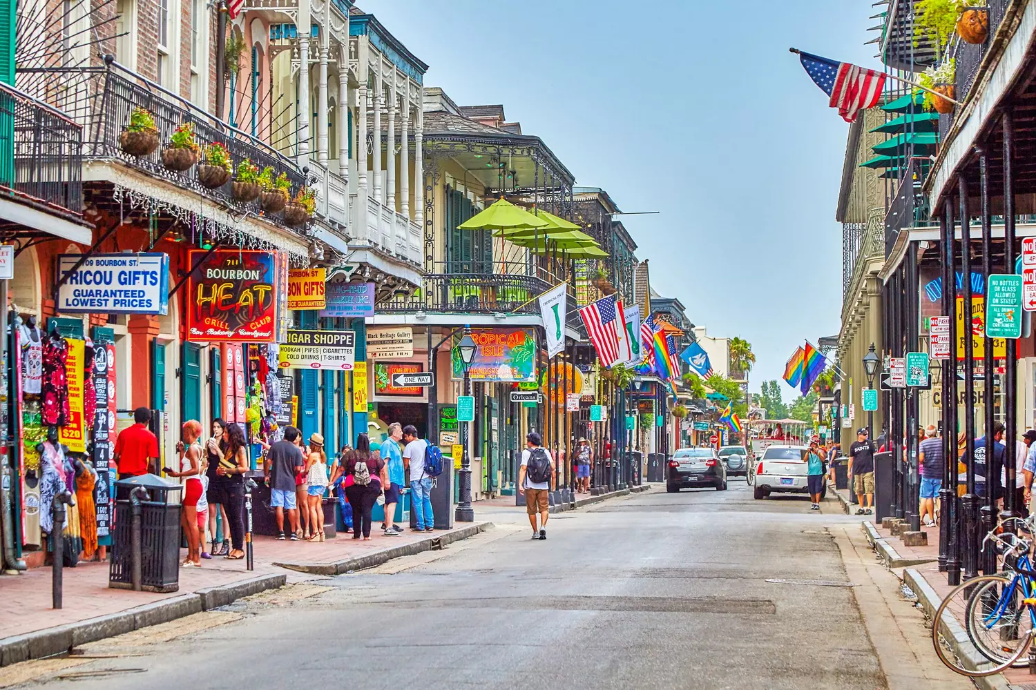 Bourbon Street in the French Quarter with colorful signs and tourists