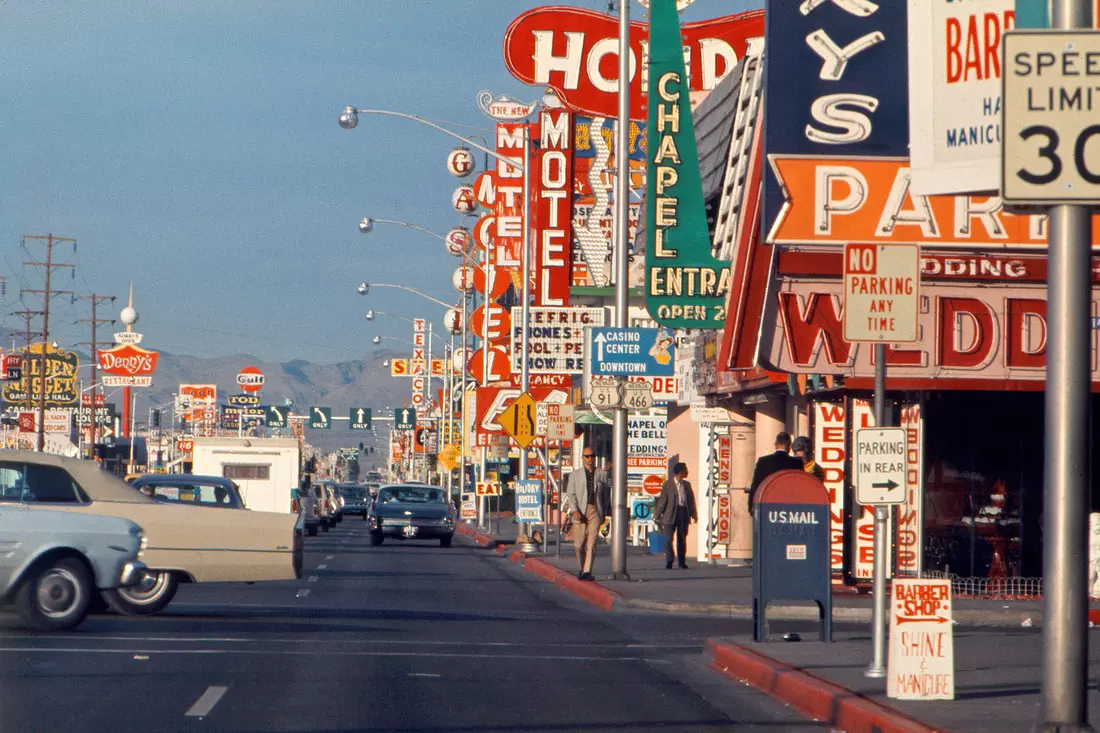 Vintage Las Vegas Strip with colorful neon signs and classic cars