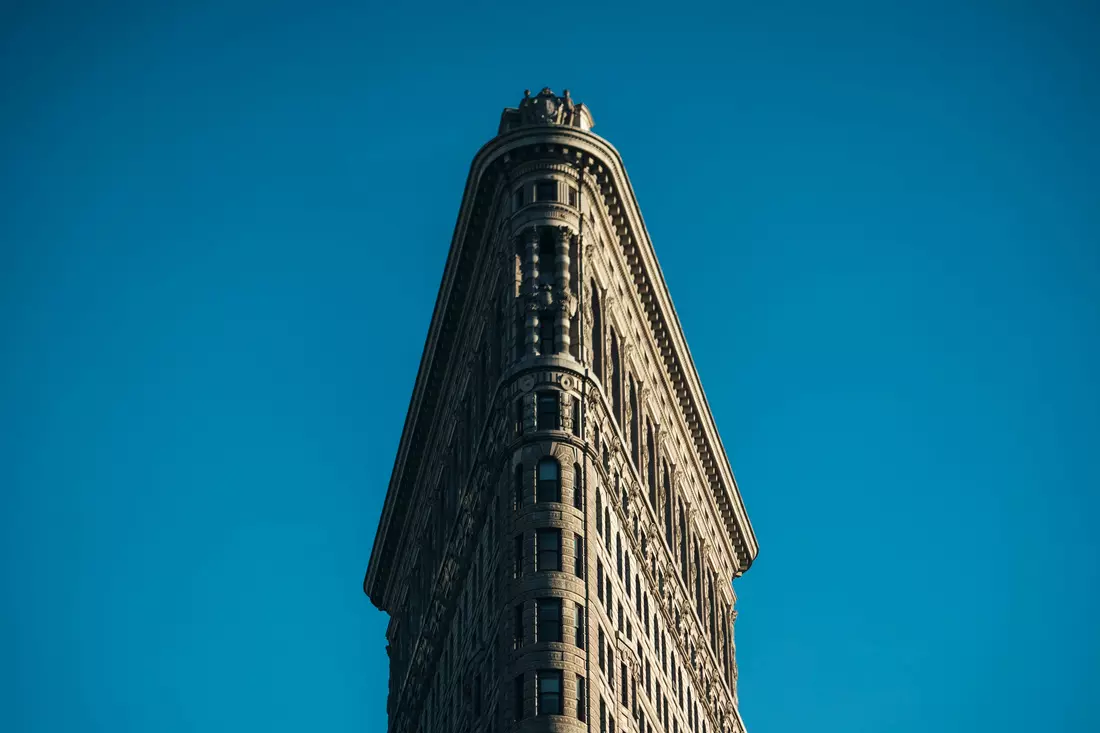 Flatiron Building: крупный план фасада на фоне ясного голубого неба