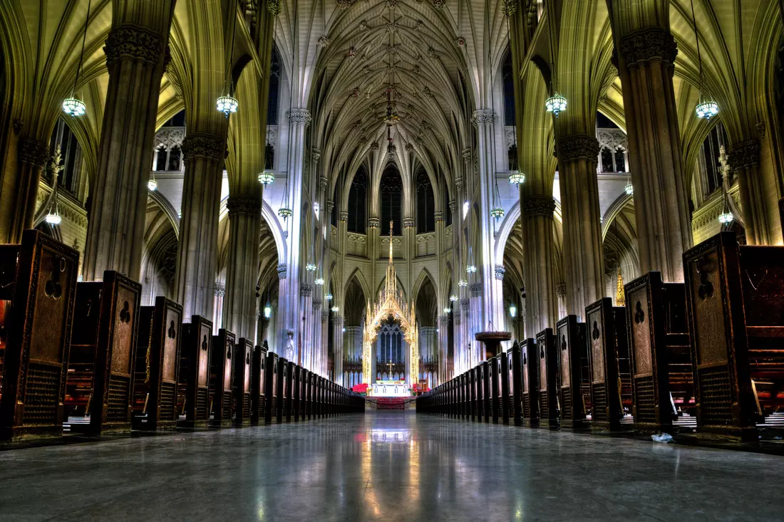 Interior of St. Patrick's Cathedral with high arches and stained glass windows in New York