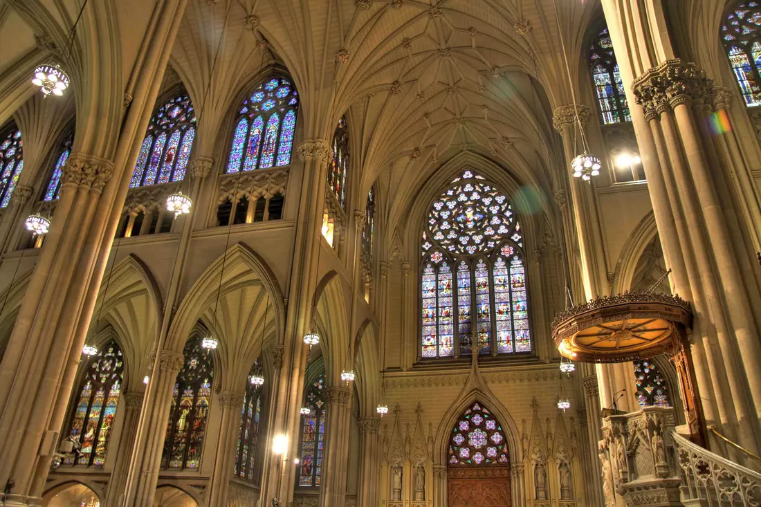 St. Patrick's Cathedral: interior space with rows of benches and translucent stained glass windows