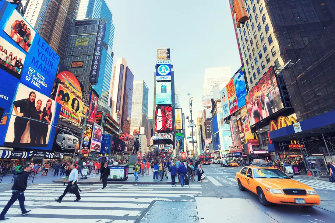 Daytime view of Times Square, bustling with people and traffic