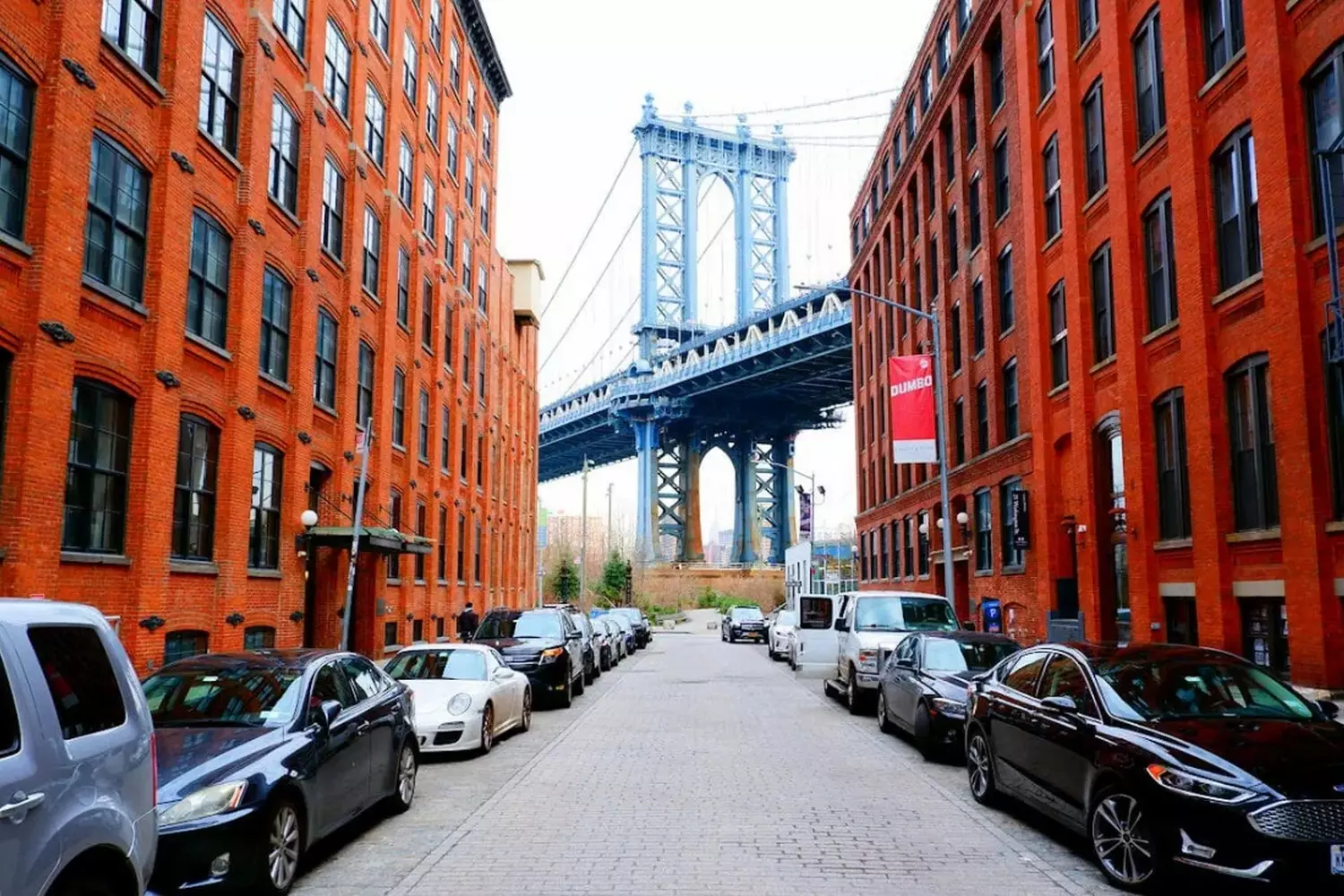 DUMBO’s Postcard View: Brooklyn Bridge & Cobblestone Charm Iconic Brooklyn Bridge towering over DUMBO’s historic streets, with Manhattan skyline in the background