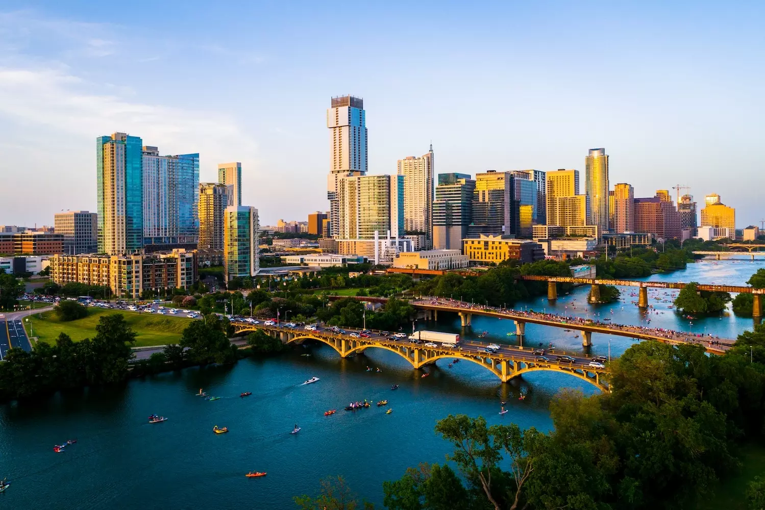 Austin Uncovered: Where Urban Pulse Meets Texas Charm A panoramic view of Austin's skyline featuring the iconic Texas State Capitol, modern high-rises, and the Colorado River winding through the city, bathed in golden sunset light