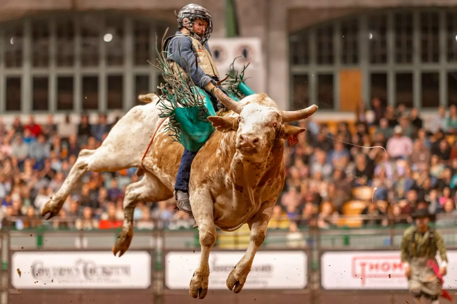 Dust & Grit: The Raw Energy of a Texas Rodeo Cowboy on a bucking bronco at a Texas rodeo arena, kicking up dust under stadium lights as the crowd cheers, capturing the state's iconic western heritage