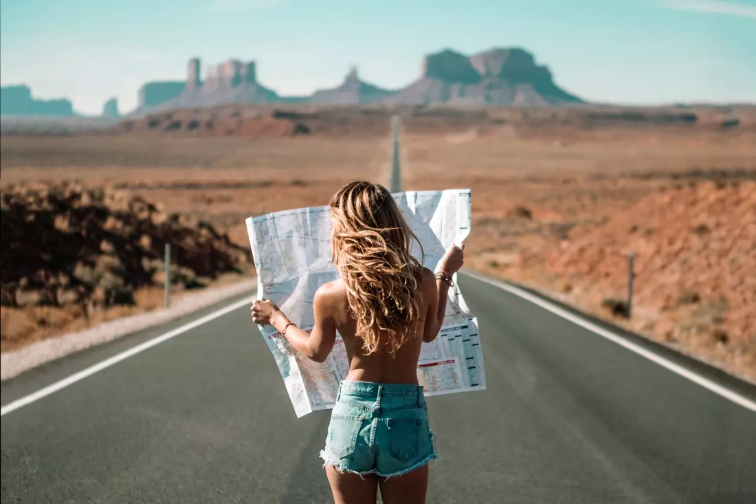 Photo of a girl with a map in her hands on a trip to the USA near Monument Valley in Arizona