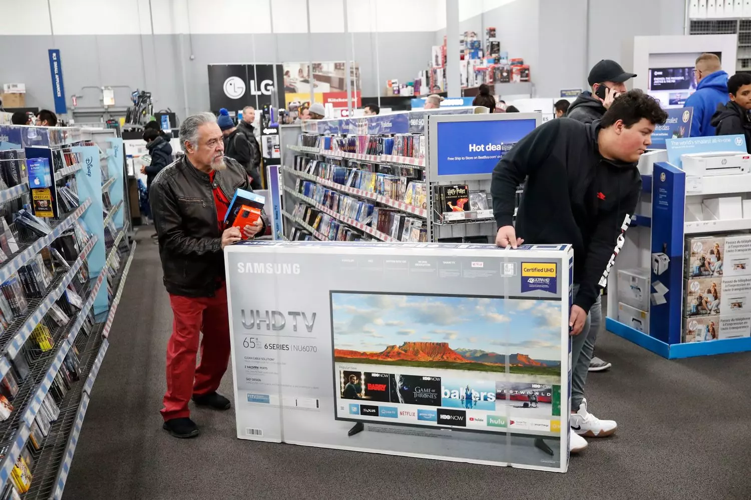 Покупатели с телевизорами и коробками в переполненном магазине Best Buy в Черную пятницу