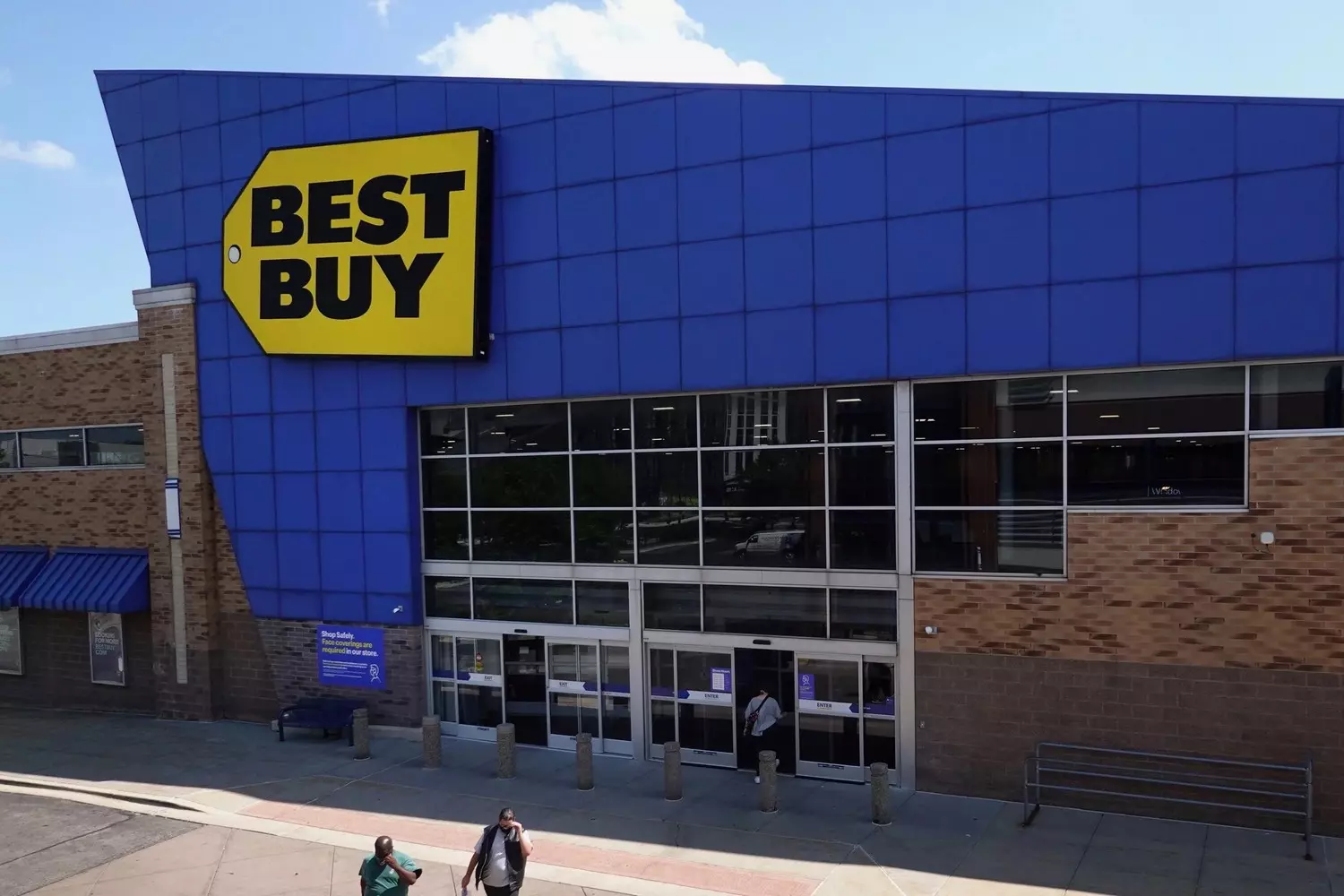 Главный вход в магазин Best Buy с большой синей вывеской и желтым ценником