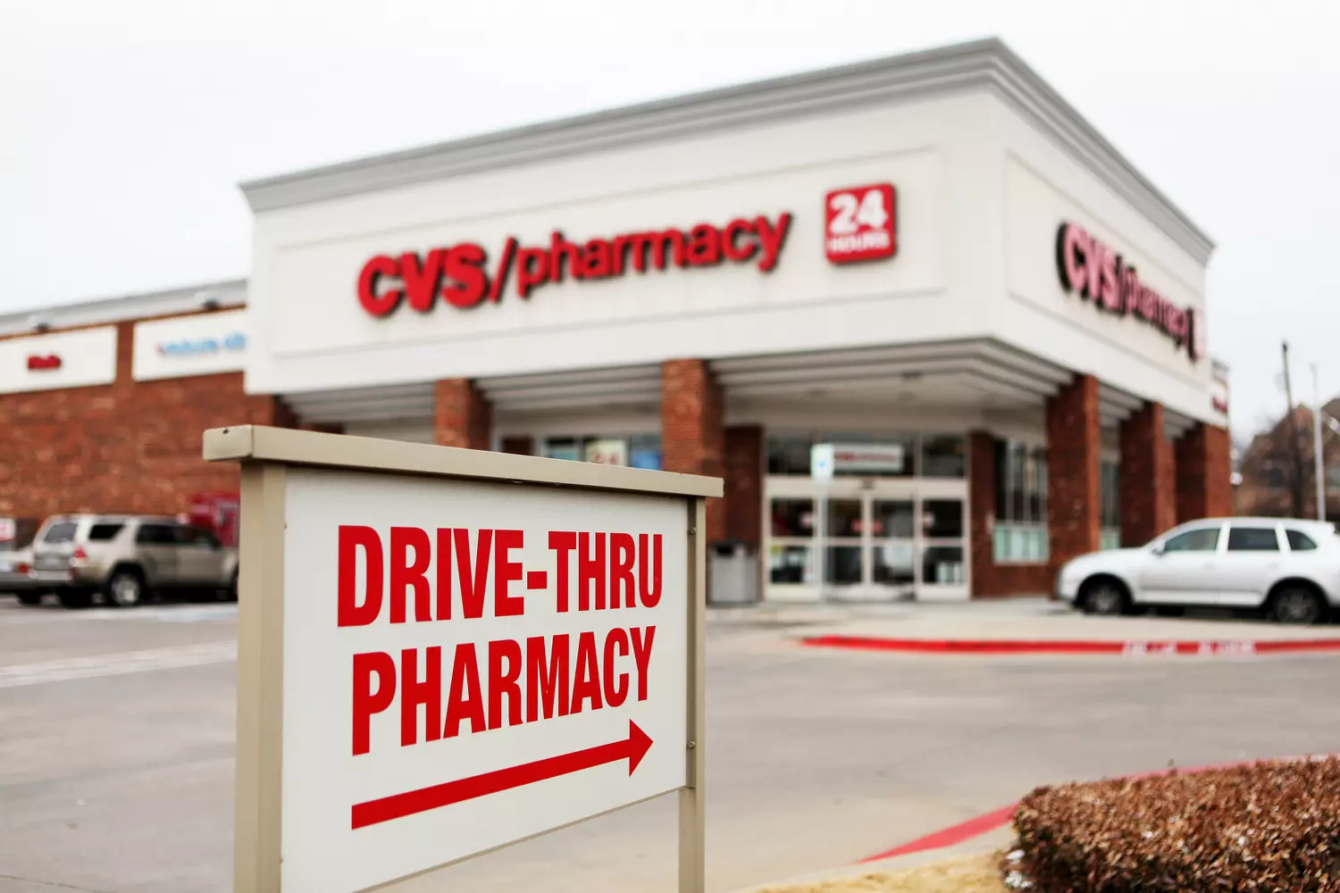 Указатель с надписью 'Drive-Thru Pharmacy' направляет к CVS/pharmacy