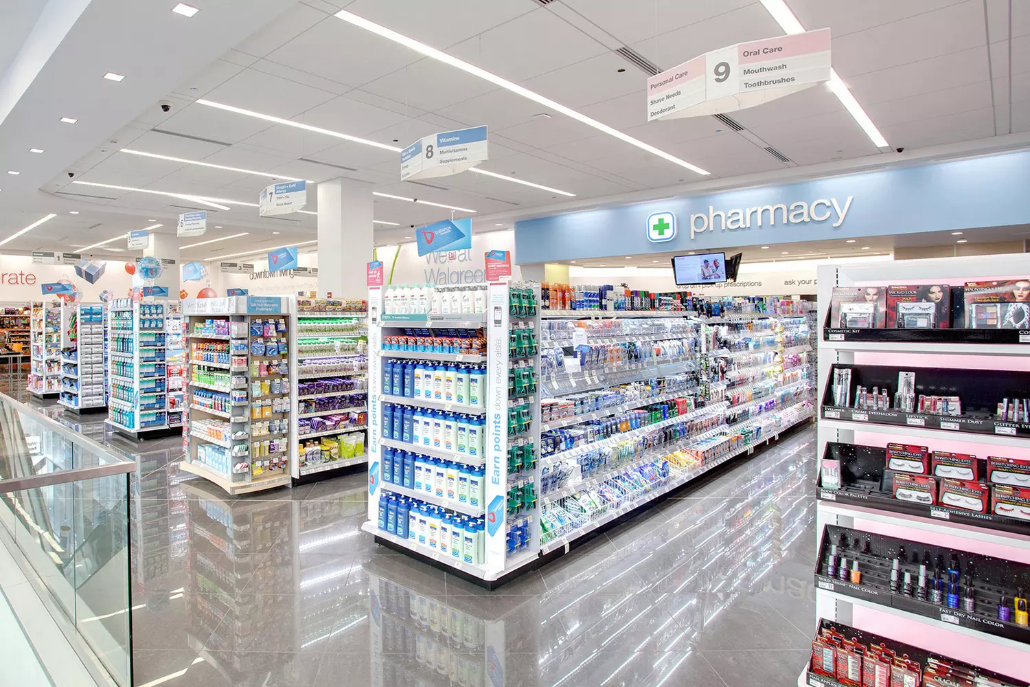 Night view of a CVS pharmacy with lights on and people passing by