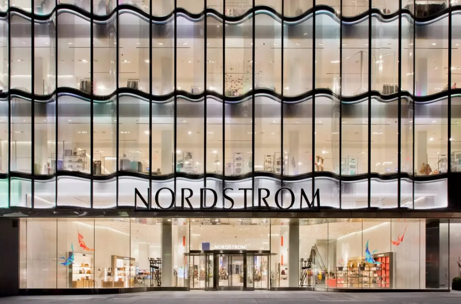 Nordstrom: роскошные покупки и безупречный сервис Современный многоэтажный универмаг Nordstrom с дизайнерскими витринами, стильным освещением и внимательными консультантами, помогающими покупателям