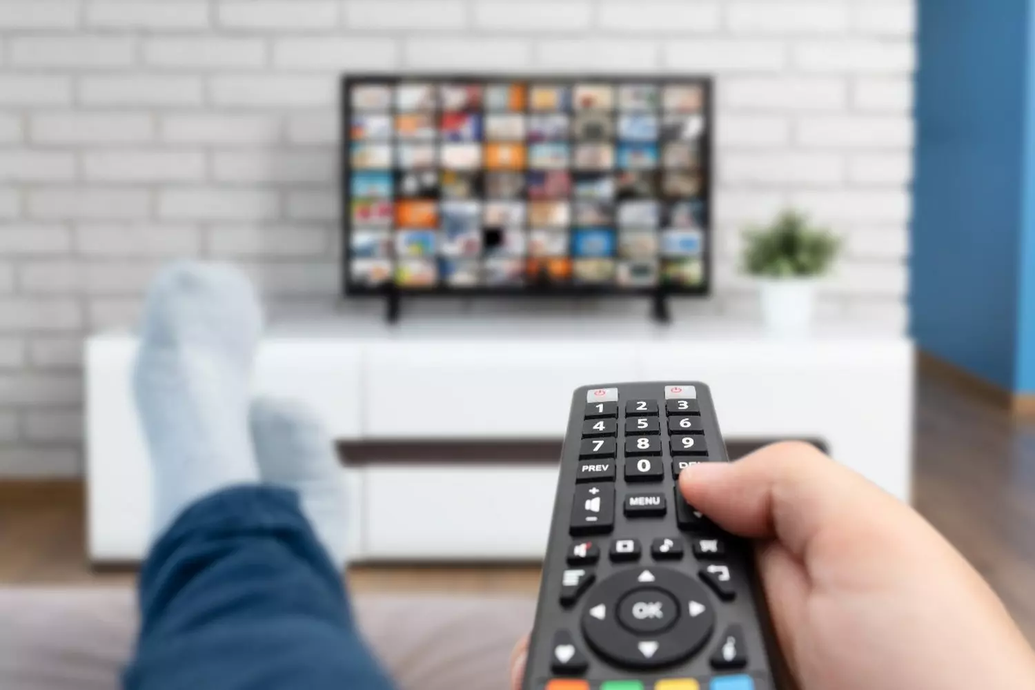 Один дома с Netflix: как смотрят стриминги в США Человек на диване смотрит популярные американские стриминговые сервисы (Netflix, Hulu) на телевизоре