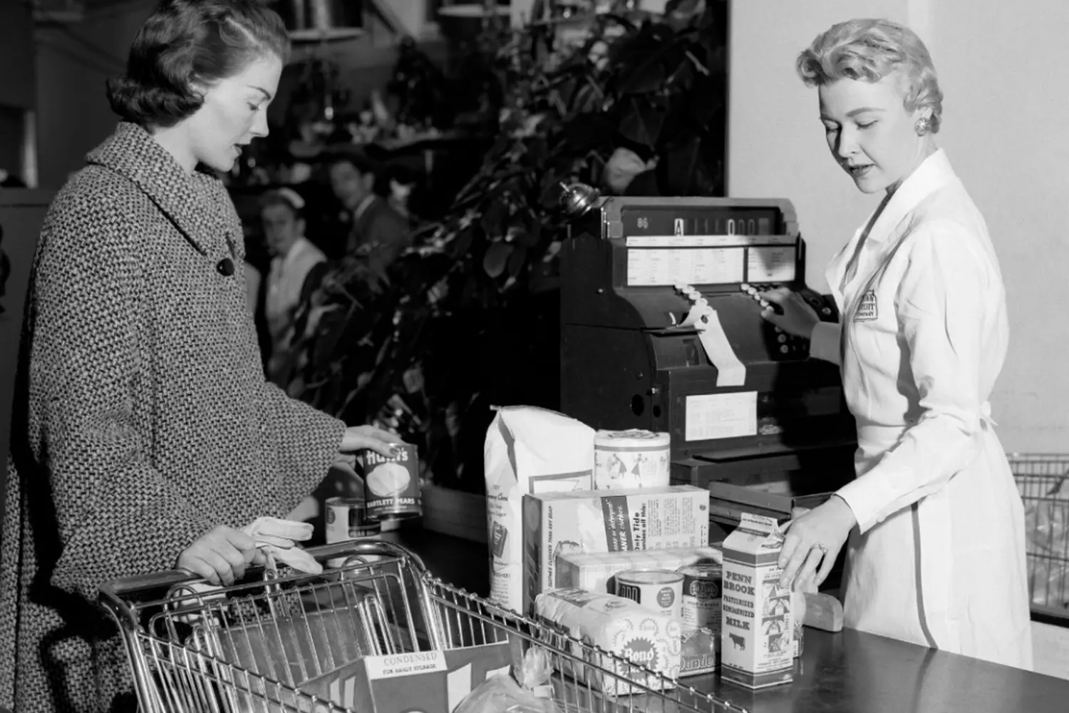 Vintage American Supermarkets: A Nostalgic Trip Down the Aisles of Time Black-and-white historical photo of classic 1950s American supermarkets with retro signage, checkout counters, and customers in vintage clothing pushing metal shopping carts