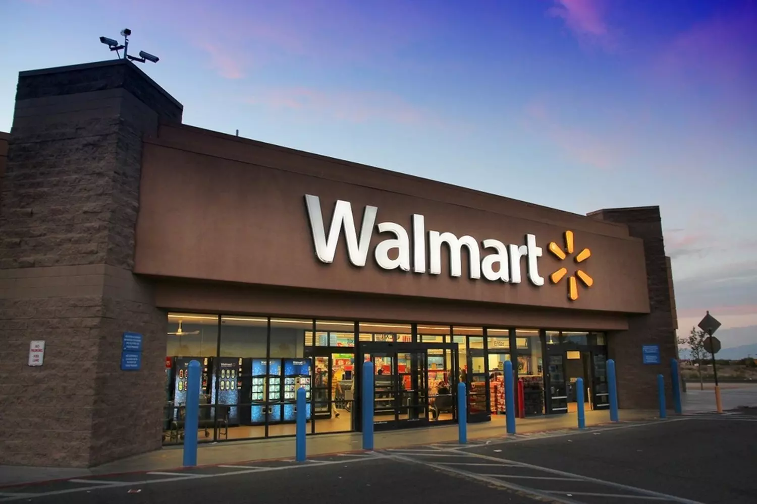Walmart USA: Iconic Superstore That Changed American Shopping Exterior view of a classic Walmart supercenter in America with the distinctive blue and white facade, large parking lot filled with cars, and the famous Walmart logo prominently displayed