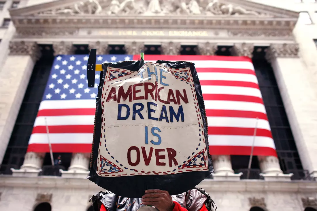 Protest with a sign "The American Dream is Over" reflects challenges and hopes