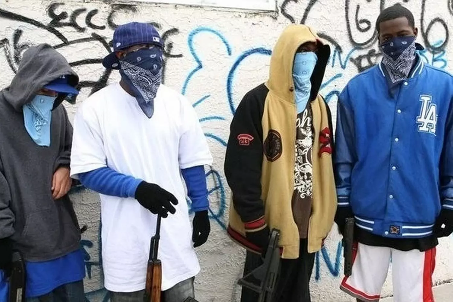 Синее господство: Члены банды Crips демонстрируют преданность на улицах США Участники уличной банды Crips собрались вместе, показывая жесты руками и повязанные синие банданы — их отличительный символ