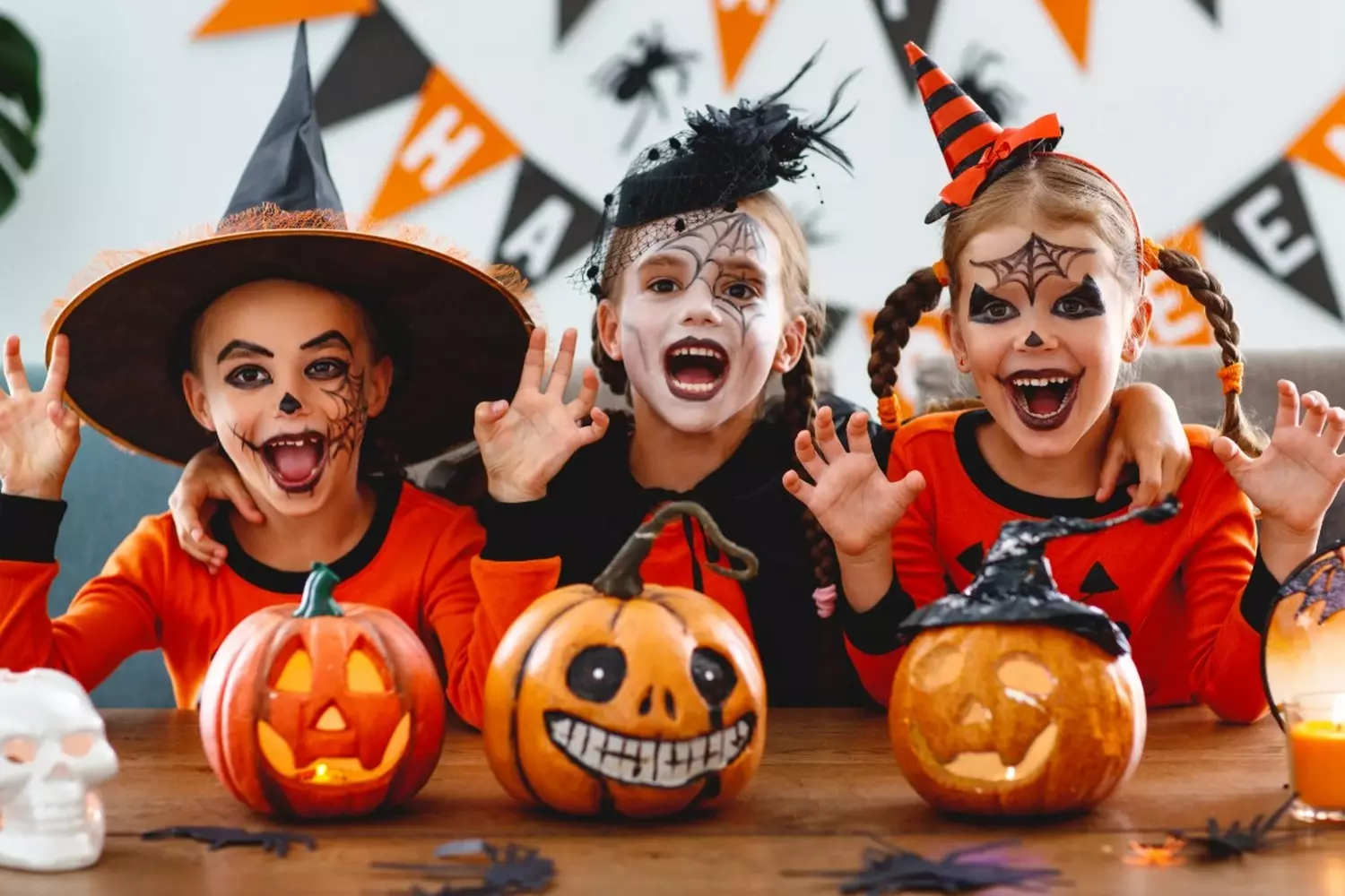 Spooky & Sweet: Kids Ready for Halloween Night Group of children in colorful Halloween costumes holding pumpkin buckets, smiling and posing together on a festive autumn night
