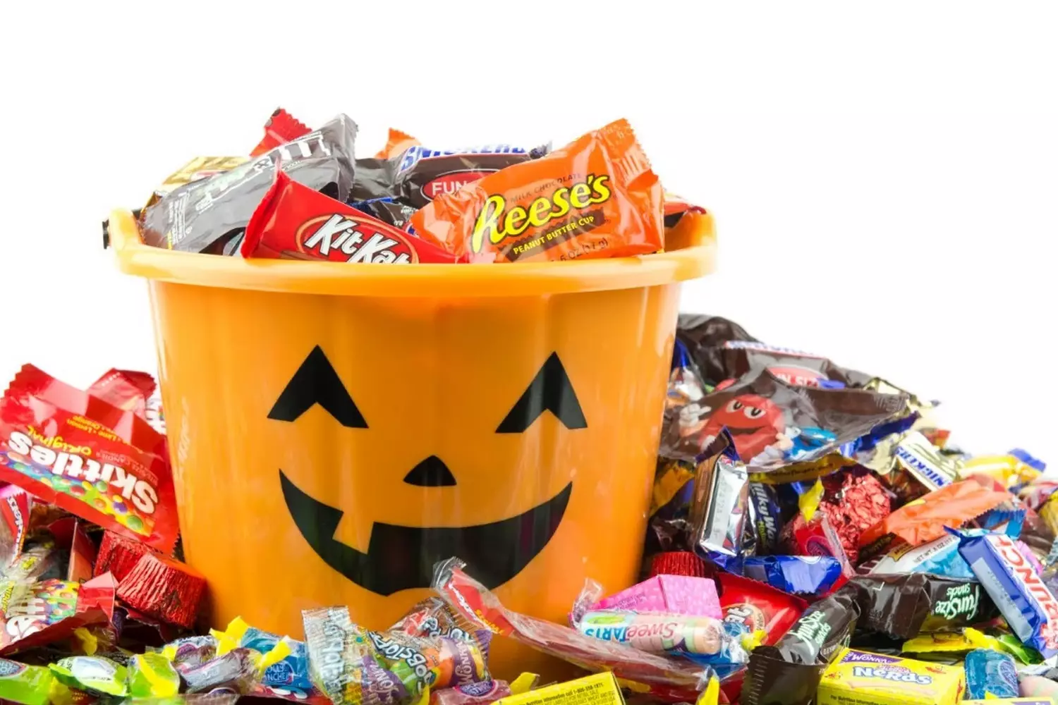 Sweet Halloween Treats: Candy Galore for Trick-or-Treaters Colorful assortment of Halloween candies in a pumpkin-shaped bowl, including chocolate bars, gummy worms, candy corn, and lollipops, arranged for trick-or-treating festivities