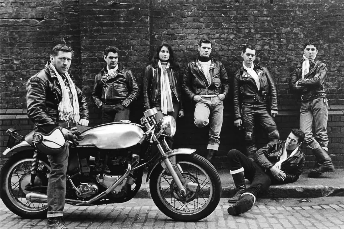 Bikers pose next to a motorcycle