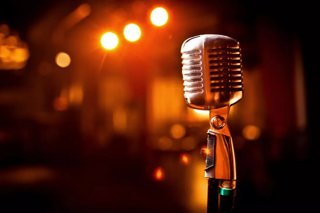 Vintage microphone on a stage, symbolizing live music and performances