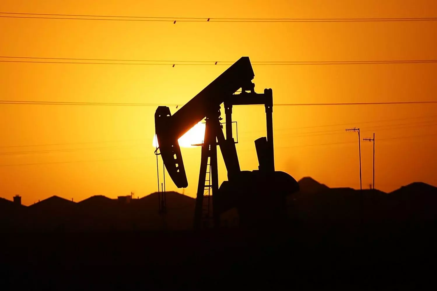 Добыча нефти в США: Основа энергетической независимости страны Современная буровая установка на нефтяном месторождении в США: рабочие и техника добывают сырую нефть под ясным небом