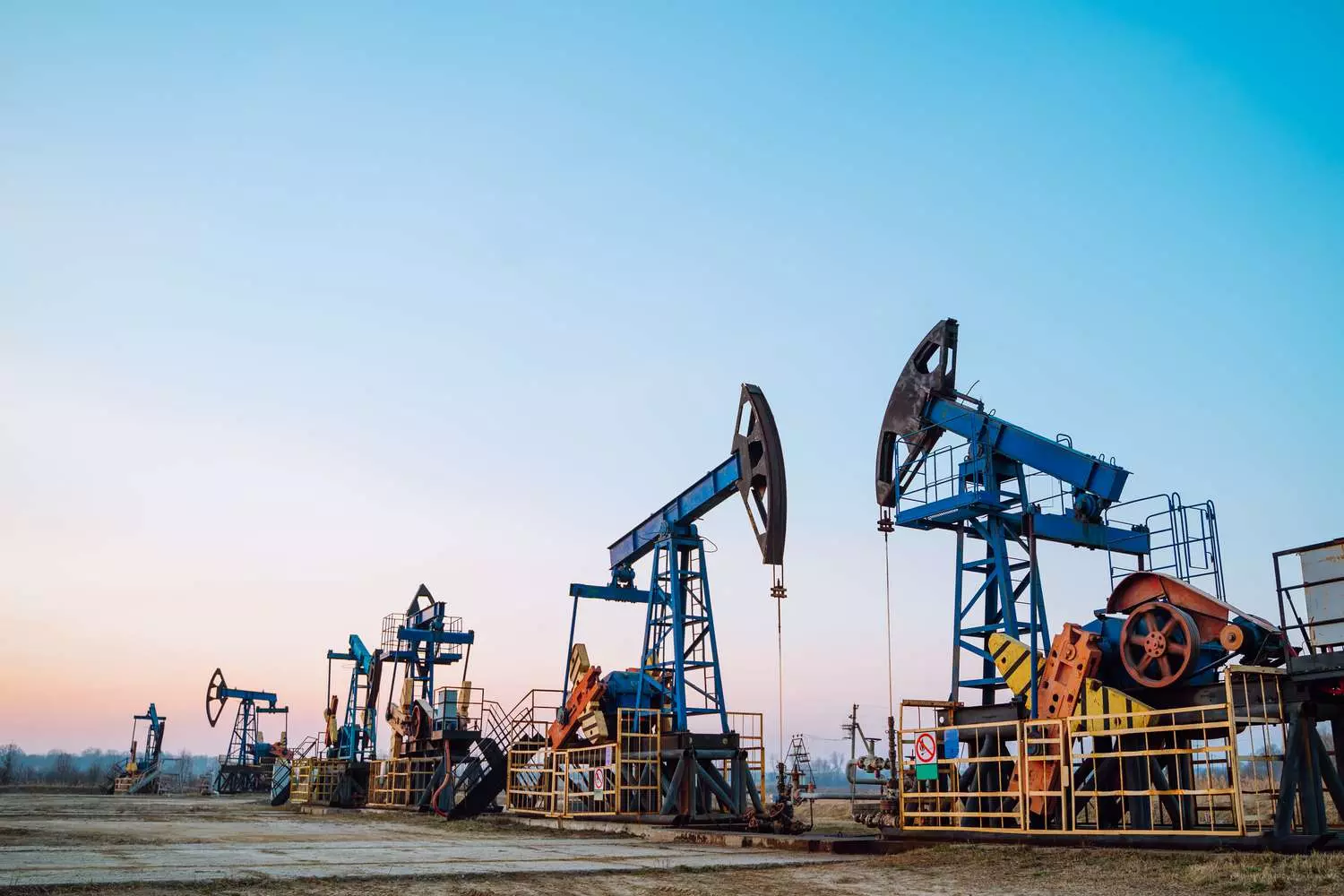 Добыча нефти в США: Основа энергетической независимости страны Современная буровая установка на нефтяном месторождении в США: рабочие и техника добывают сырую нефть под ясным небом